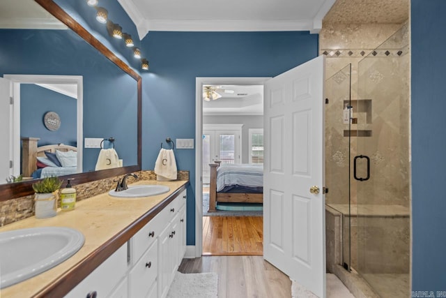 ensuite bathroom featuring a sink, ensuite bath, a shower stall, and ornamental molding