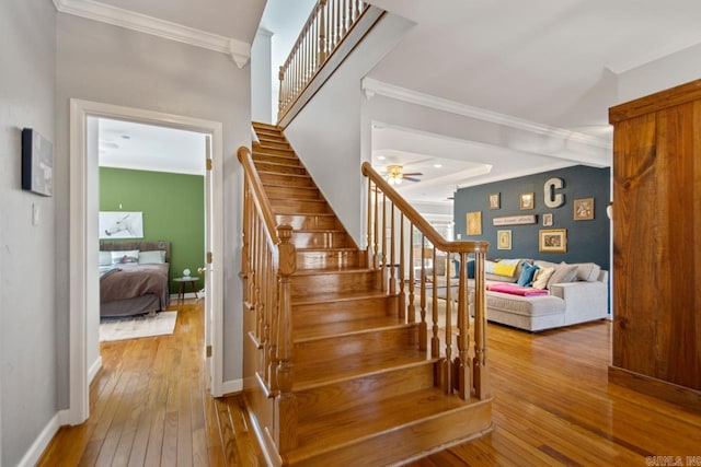 stairs featuring ornamental molding, baseboards, and hardwood / wood-style flooring