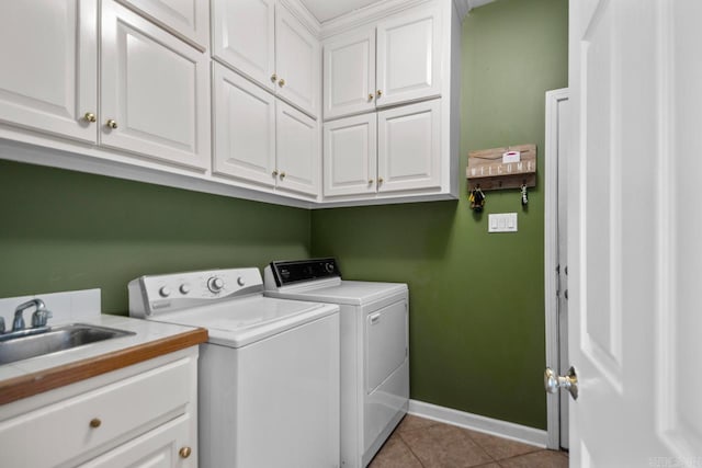 laundry room featuring independent washer and dryer, a sink, cabinet space, light tile patterned floors, and baseboards