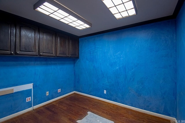 spare room with dark wood-type flooring and baseboards