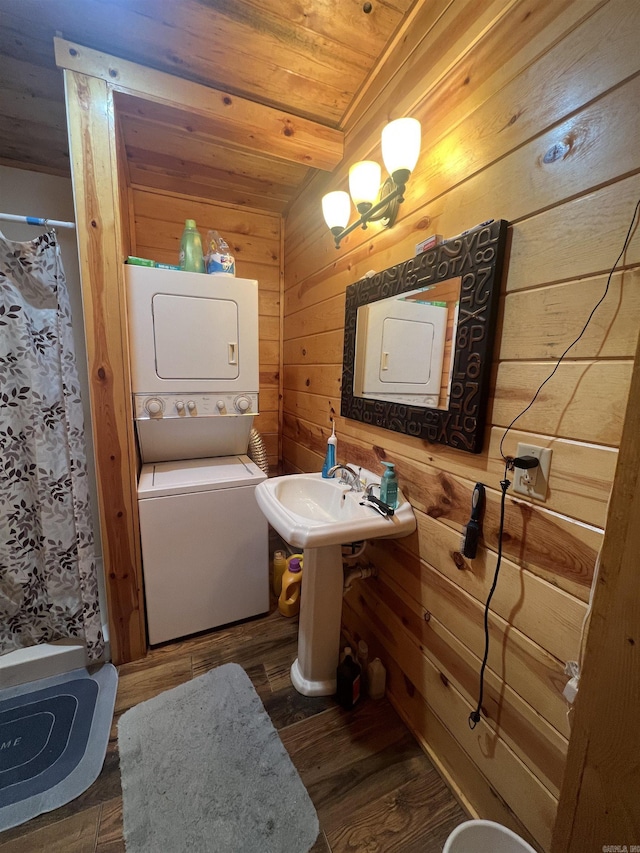 full bath with a shower with shower curtain, wood finished floors, stacked washer and dryer, wood ceiling, and wood walls