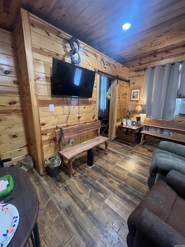 living room featuring a barn door, wood finished floors, wood walls, and wooden ceiling