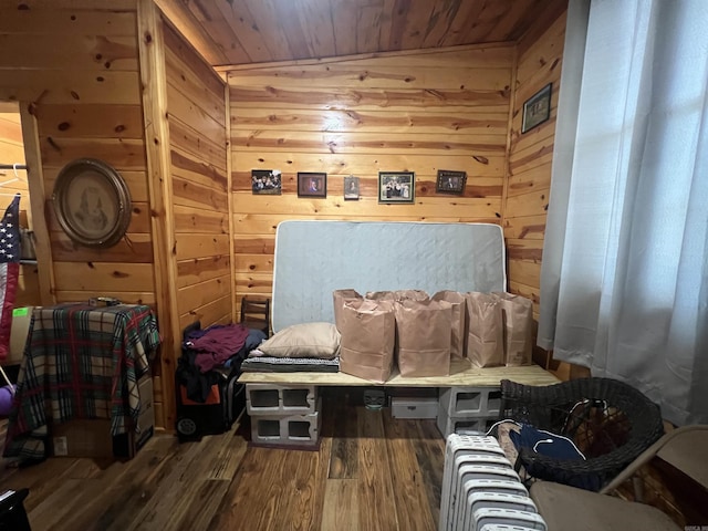 living area featuring wood finished floors, wooden walls, and wooden ceiling