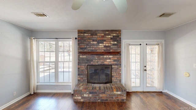 unfurnished living room featuring visible vents, a healthy amount of sunlight, and dark wood-style flooring