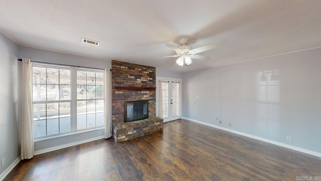 unfurnished living room with visible vents, baseboards, dark wood-type flooring, and a ceiling fan