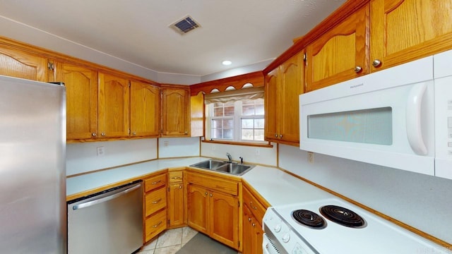 kitchen with brown cabinetry, visible vents, appliances with stainless steel finishes, and a sink