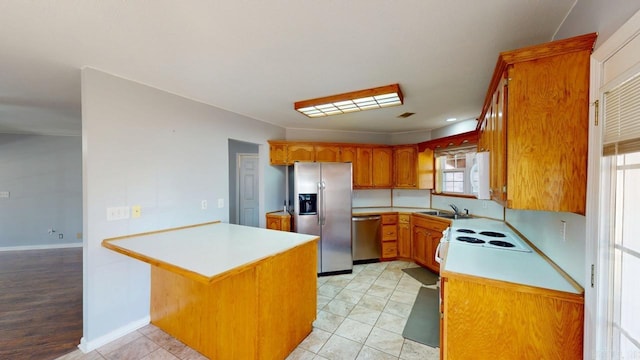 kitchen featuring a peninsula, light countertops, appliances with stainless steel finishes, and a sink