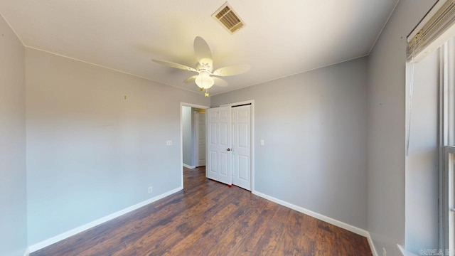 unfurnished bedroom featuring visible vents, baseboards, dark wood finished floors, a closet, and a ceiling fan