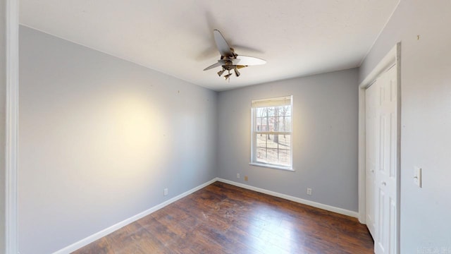 unfurnished bedroom featuring a closet, ceiling fan, baseboards, and dark wood-style flooring