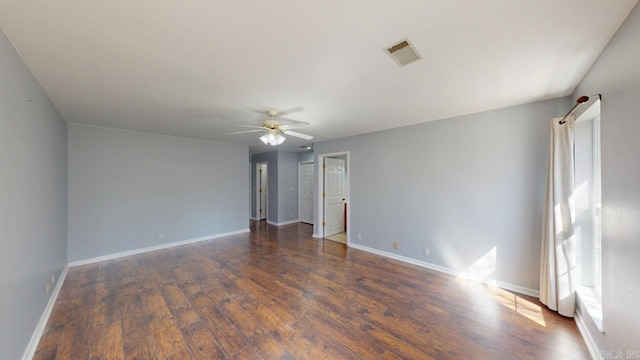 unfurnished room with visible vents, baseboards, wood finished floors, and a ceiling fan