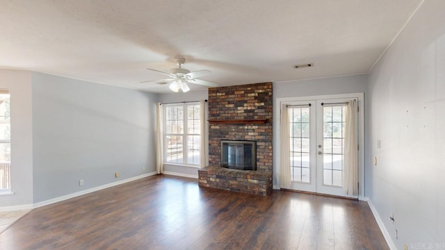 unfurnished living room featuring a wealth of natural light, baseboards, ceiling fan, and wood finished floors