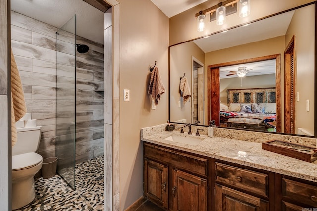 bathroom with toilet, a ceiling fan, ensuite bathroom, and tiled shower