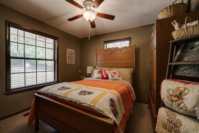 carpeted bedroom featuring baseboards, visible vents, a textured ceiling, and ceiling fan