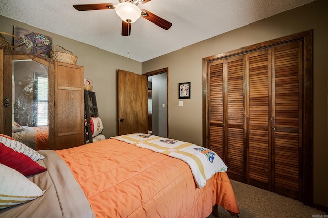 carpeted bedroom with a closet, a textured ceiling, and ceiling fan