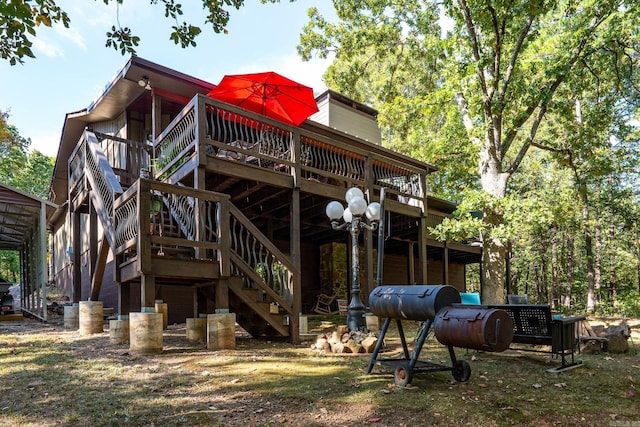 rear view of property featuring stairs, a wooden deck, and a chimney