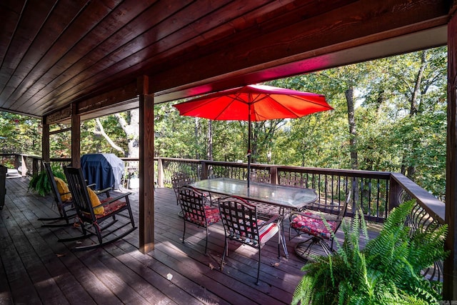 wooden terrace with a grill and outdoor dining space