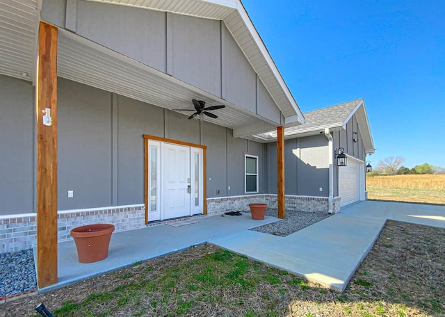 exterior space with an attached garage and a ceiling fan