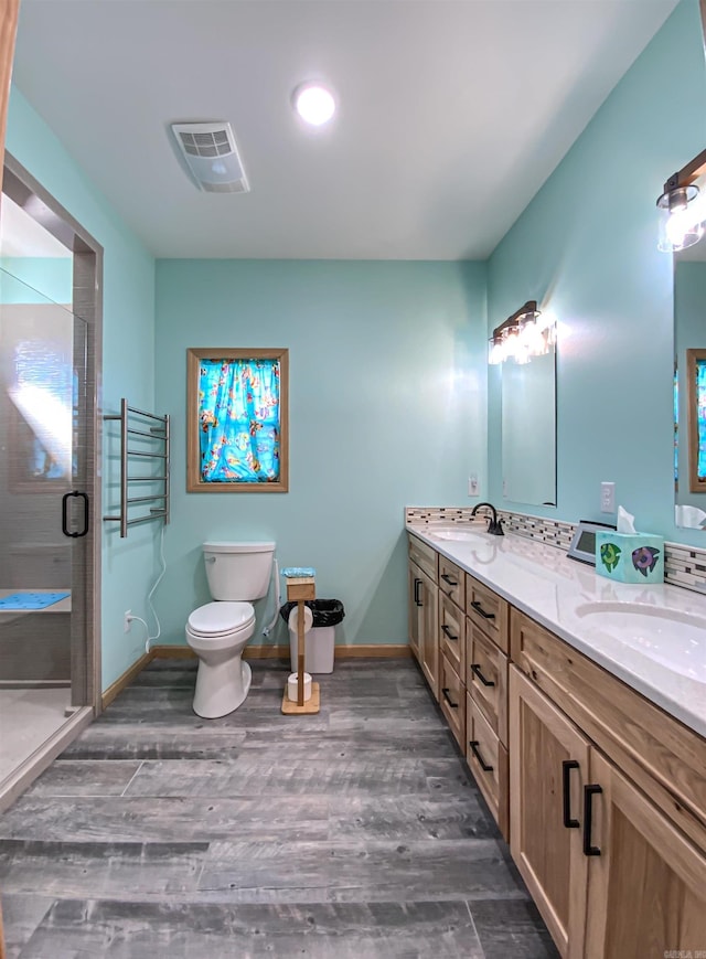 bathroom featuring visible vents, a shower stall, wood finished floors, and a sink