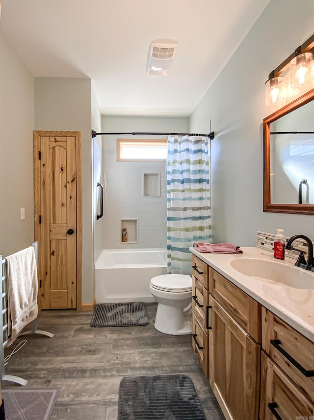 full bath featuring vanity, wood finished floors, visible vents, shower / tub combo, and toilet