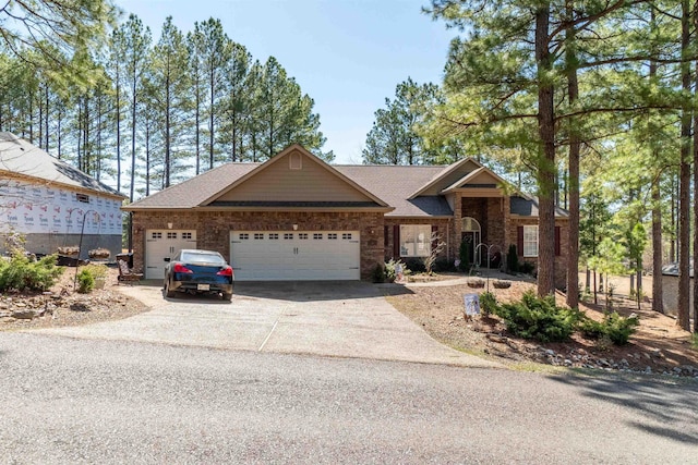 view of front of home with driveway, a shingled roof, and a garage