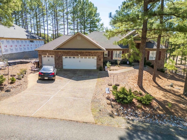 view of front of house with driveway, brick siding, an attached garage, and a shingled roof