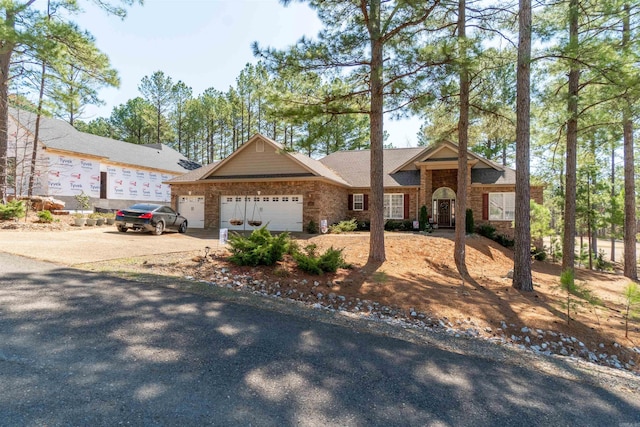 view of front facade with brick siding, concrete driveway, and an attached garage