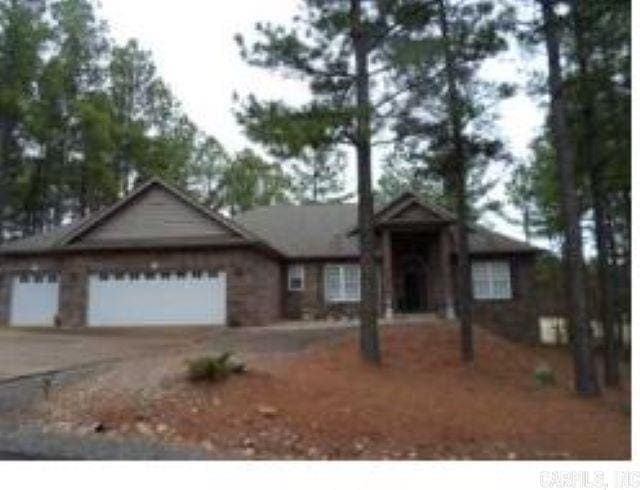 ranch-style house featuring a garage and driveway