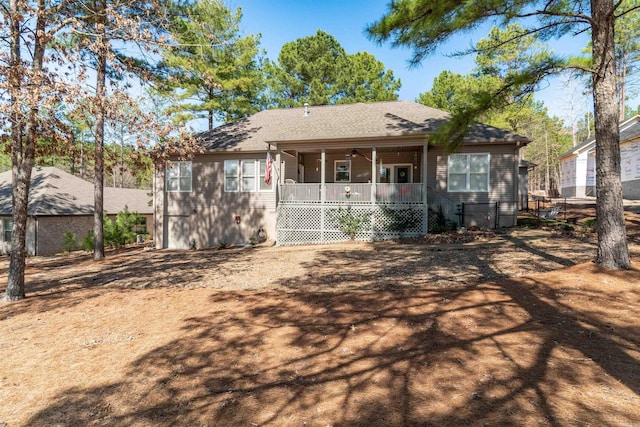 back of property featuring covered porch and a shingled roof