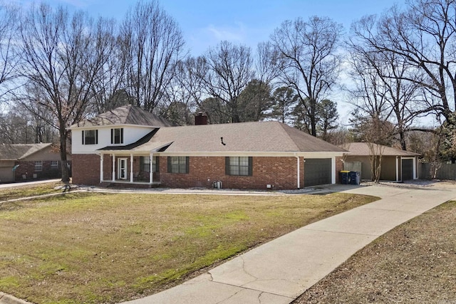 traditional home with brick siding, a front lawn, concrete driveway, a chimney, and an attached garage