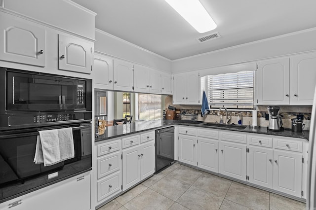 kitchen with dark countertops, visible vents, crown molding, black appliances, and a sink