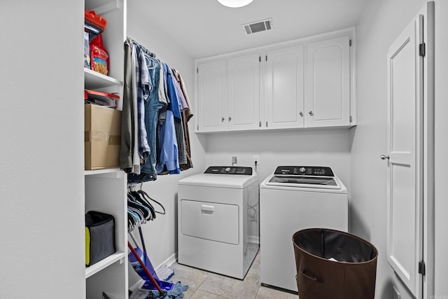 washroom with cabinet space, visible vents, and washing machine and clothes dryer