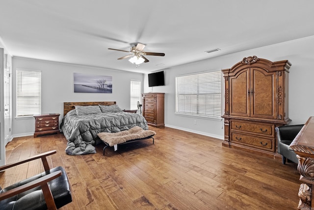 bedroom featuring visible vents, multiple windows, and light wood-style floors