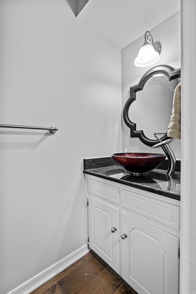 bathroom featuring baseboards, wood finished floors, and vanity