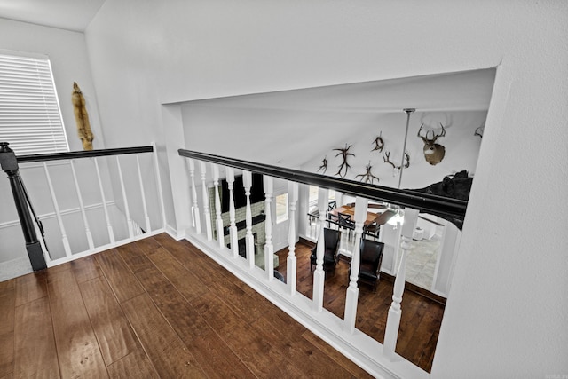 hallway with an upstairs landing, plenty of natural light, and wood-type flooring