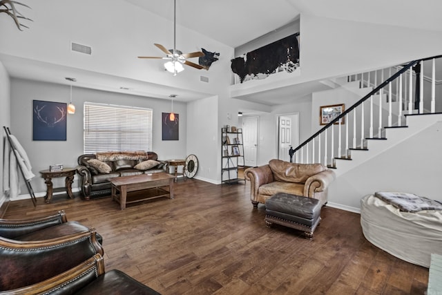 living area with dark wood-type flooring, baseboards, stairway, high vaulted ceiling, and a ceiling fan