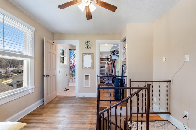 entrance foyer with baseboards, a ceiling fan, and wood finished floors