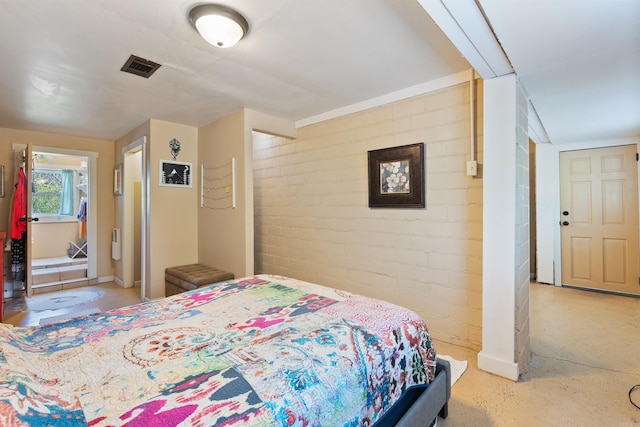 bedroom with visible vents and brick wall