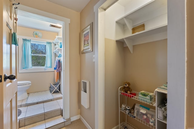 bathroom featuring visible vents, baseboards, toilet, and tile patterned flooring