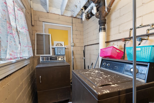 washroom with laundry area, washer and dryer, and concrete block wall