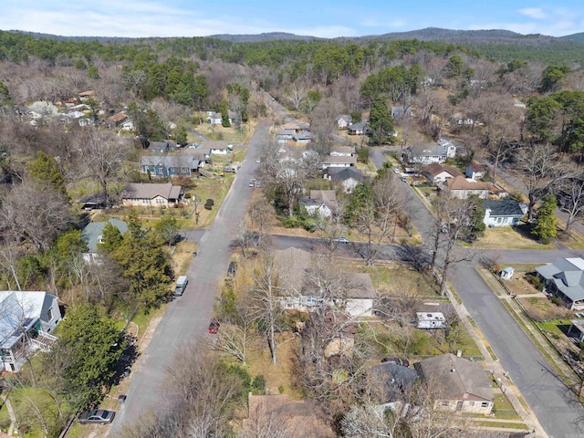 drone / aerial view with a mountain view, a wooded view, and a residential view