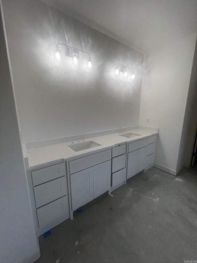 bathroom featuring double vanity, unfinished concrete flooring, and a sink