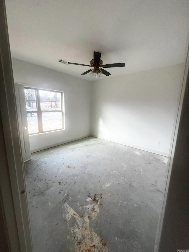 unfurnished room featuring visible vents, concrete floors, and a ceiling fan