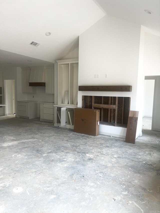 unfurnished living room with visible vents and lofted ceiling