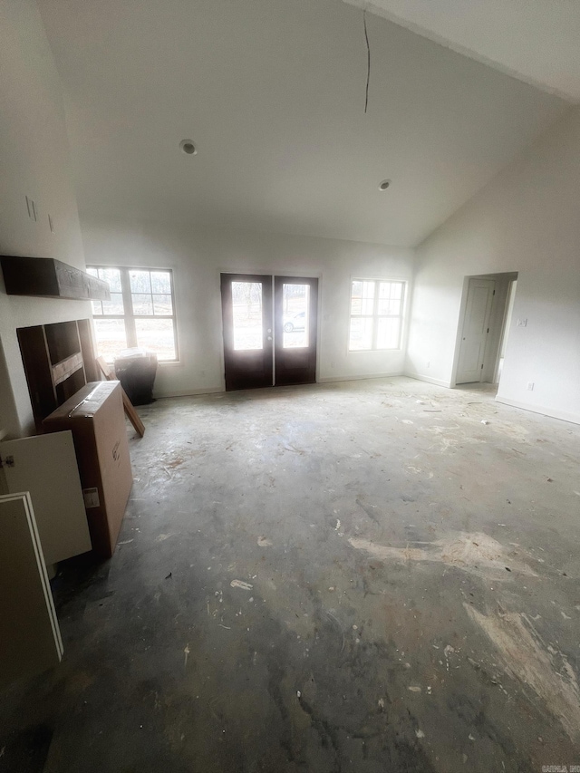 unfurnished living room featuring a healthy amount of sunlight and high vaulted ceiling