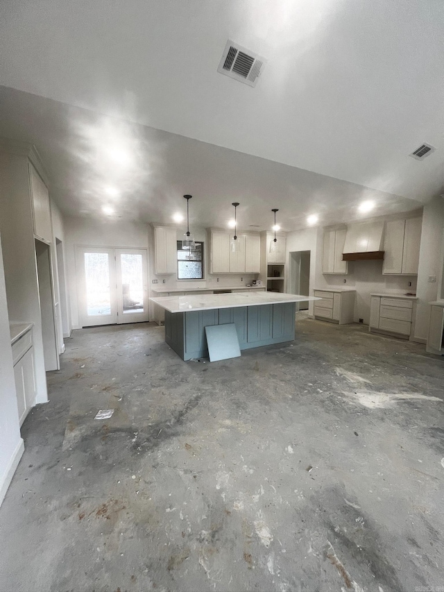 kitchen featuring a spacious island, visible vents, french doors, and decorative light fixtures