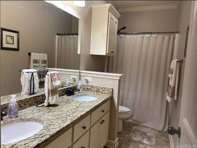 bathroom with double vanity, ornamental molding, toilet, and a sink