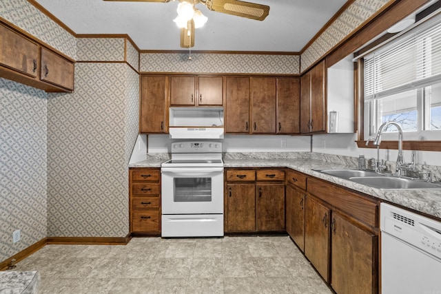 kitchen with a sink, white appliances, and wallpapered walls