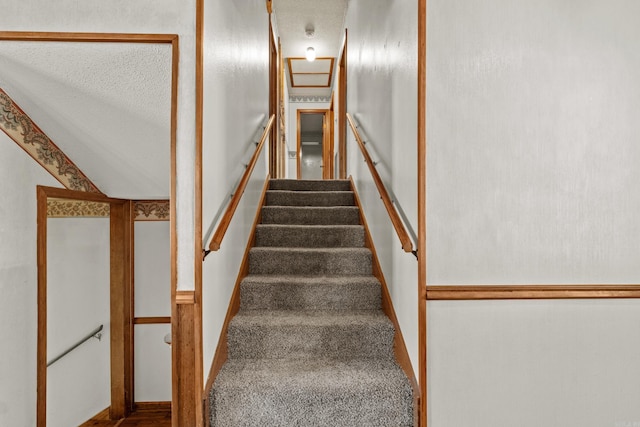 stairs with a textured ceiling