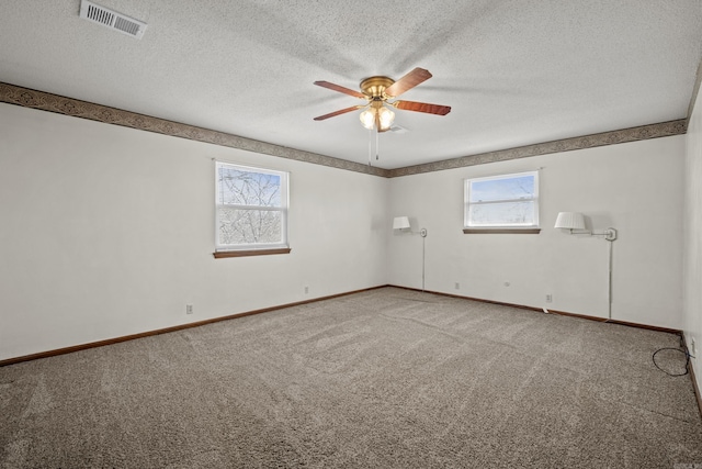 empty room with visible vents, baseboards, a ceiling fan, and carpet floors