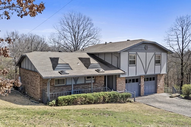 tudor-style house with a front yard, brick siding, a porch, and driveway